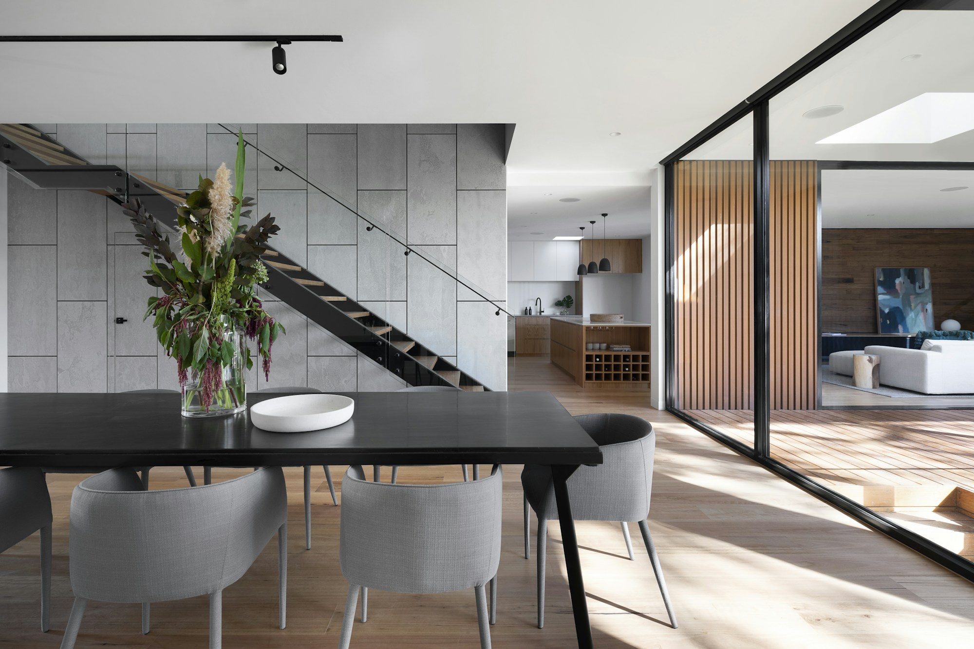 An open-plan home connected by light, timber and simple furniture